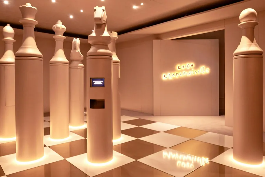 CHANEL Le Grand Numéro: übergroße Schachfiguren auf kariertem Boden im Raum von COCO MADEMOISELLE