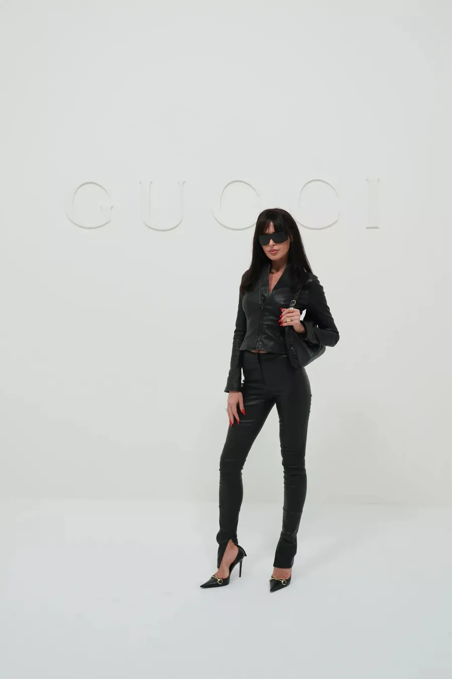 Gucci The Store Show: Frau ganz in schwarzem Leder mit schwarzer Schultertasche