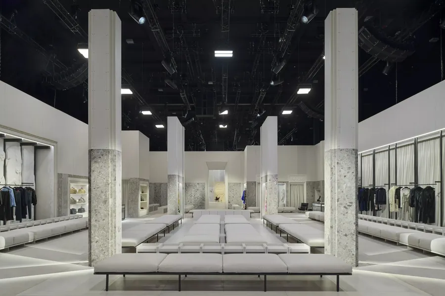 Gucci The Store Show: der als Laden gestaltete Showraum mit hellen Sitzbänken, Steinsäulen und Kleiderstangen